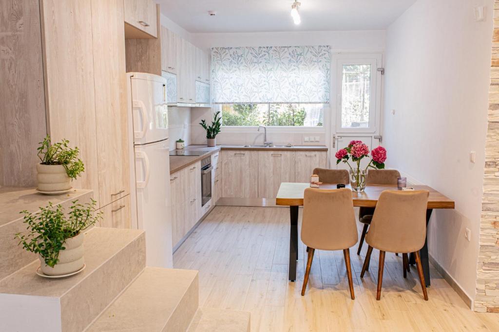 eine Küche mit einem Tisch und Stühlen sowie eine Küche mit weißen Geräten in der Unterkunft Anastasia's Apartment in Ioannina