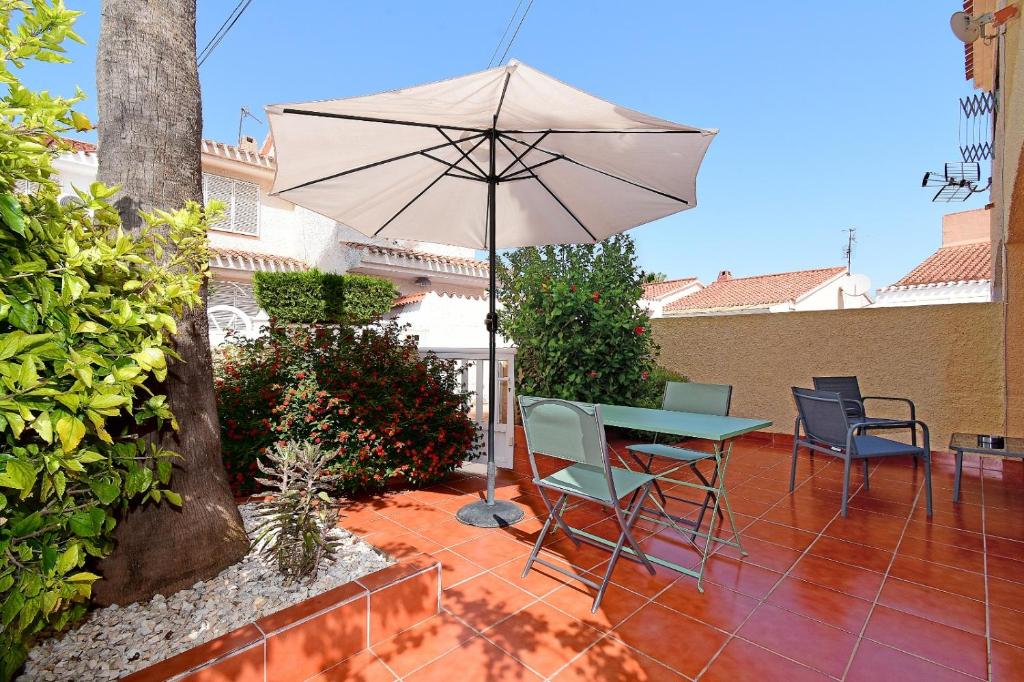 a patio with a table and an umbrella at Violeta 17 in Los Urrutias