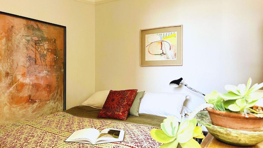 um quarto com uma cama com um livro e uma planta em Lovely 3-Bed Apartment & garden & dog friendly em Londres
