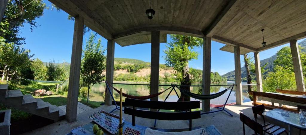 a porch with a hammock and a view at Vikendica pored Drine Foča in Handići