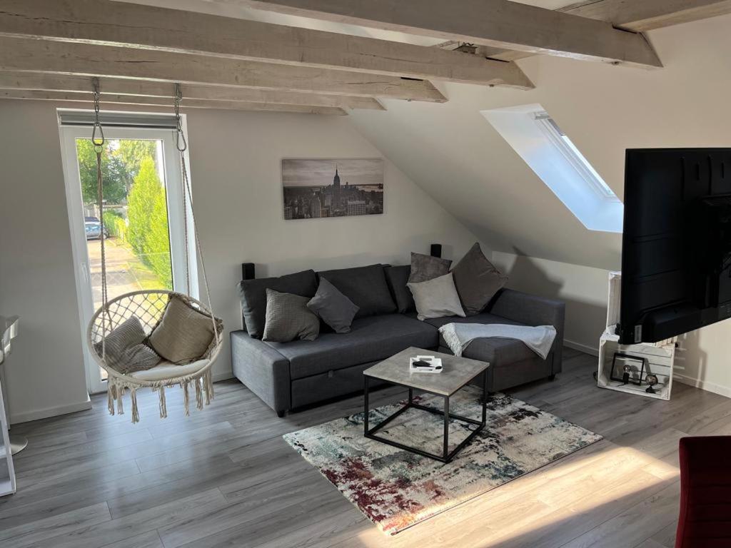 ein Wohnzimmer mit einem Sofa und einem TV in der Unterkunft Willkommen Zuhause - Traumhafte, zentrale Ferienwohnung in Kurstadt in Bad Oeynhausen