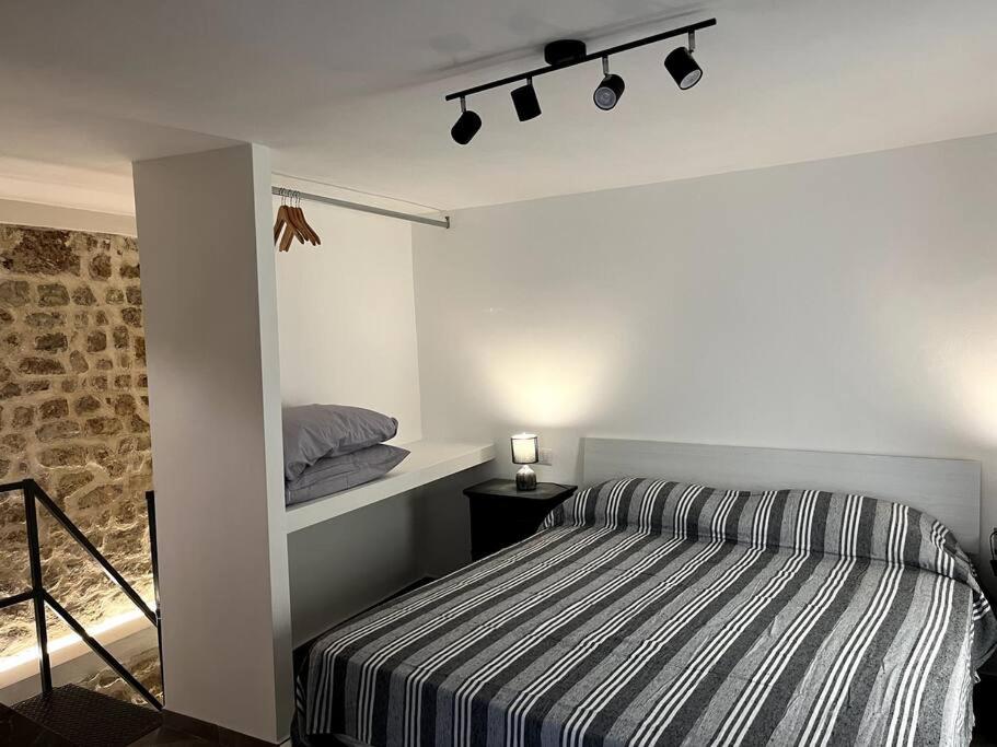1 dormitorio con 1 cama con manta a rayas en Appartamento Porta Maggio II, en Terracina