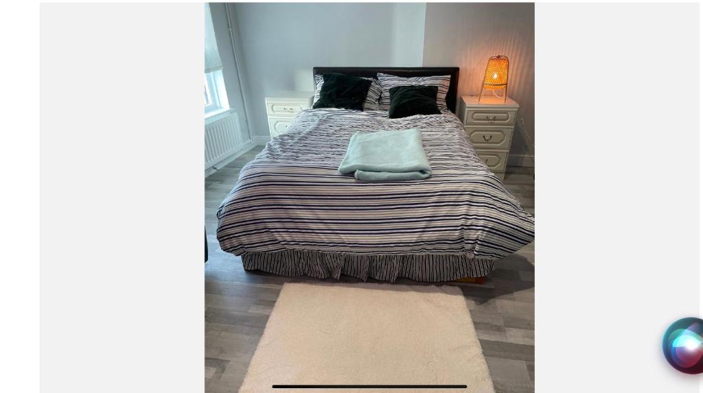 a bedroom with a large bed and a rug at Road to home in Abbey Wood