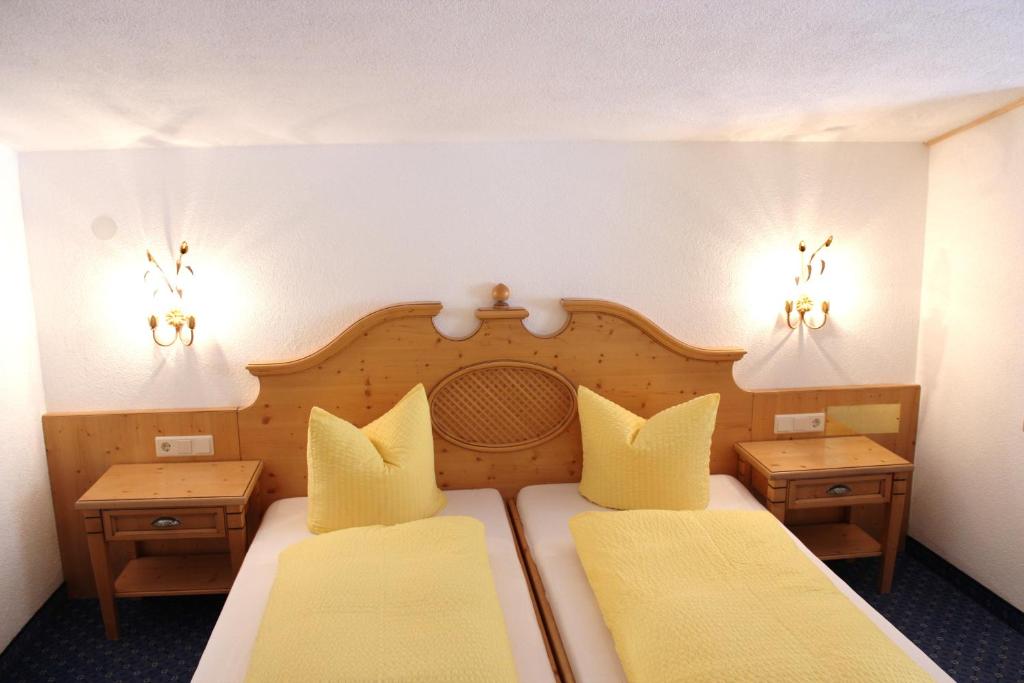 a hotel room with two beds and two tables at Apart Pfeifer in Ischgl