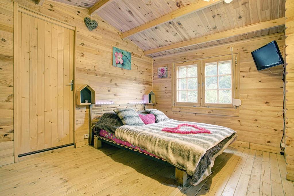 a bedroom with a bed in a wooden cabin at La romance. in Prugnanes