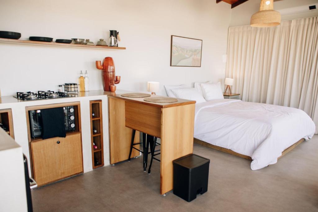 a bedroom with a bed and a desk with a kitchen at Paradise Ranch Chapada dos Veadeiros in Alto Paraíso de Goiás