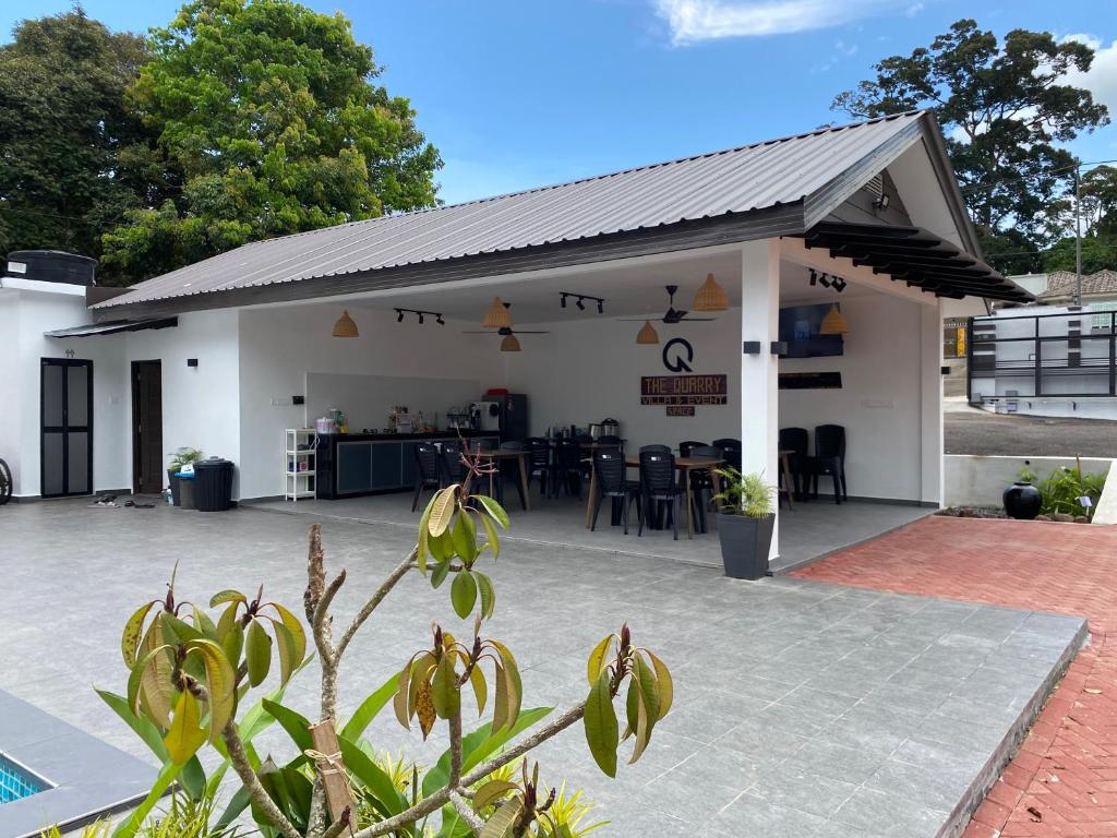 a white building with a roof and a patio at Villa The Quarry in Segamat