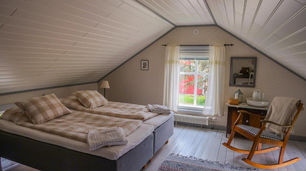 een slaapkamer met een bed, een tafel en een raam bij Lillstugan in Vöyri