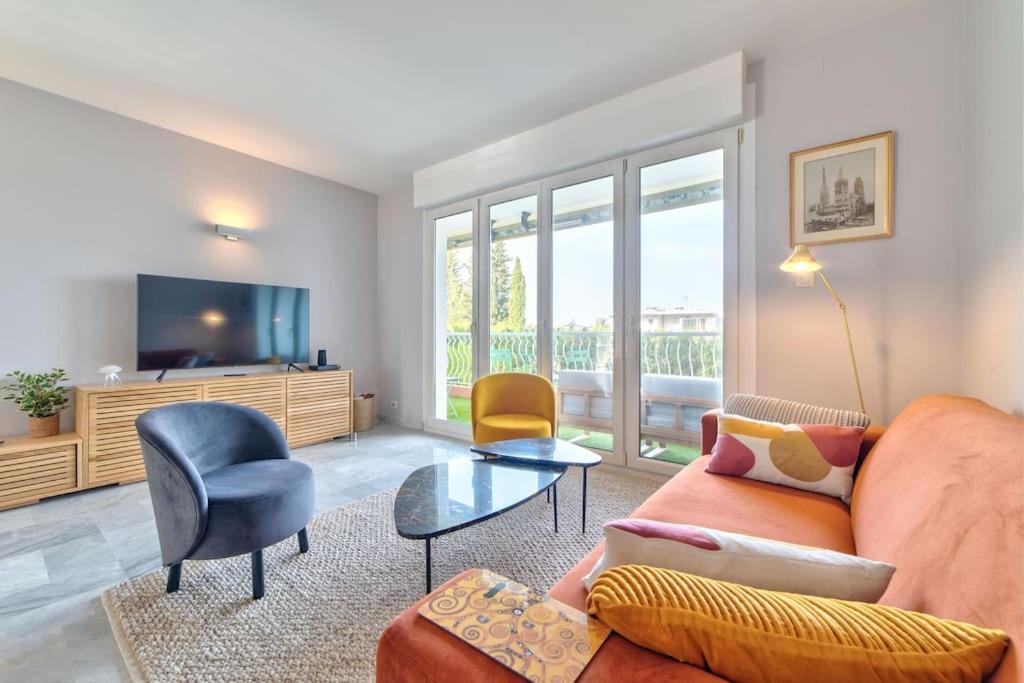 un salon avec un canapé et une télévision dans l'établissement ROSE DES SABLES, à Antibes