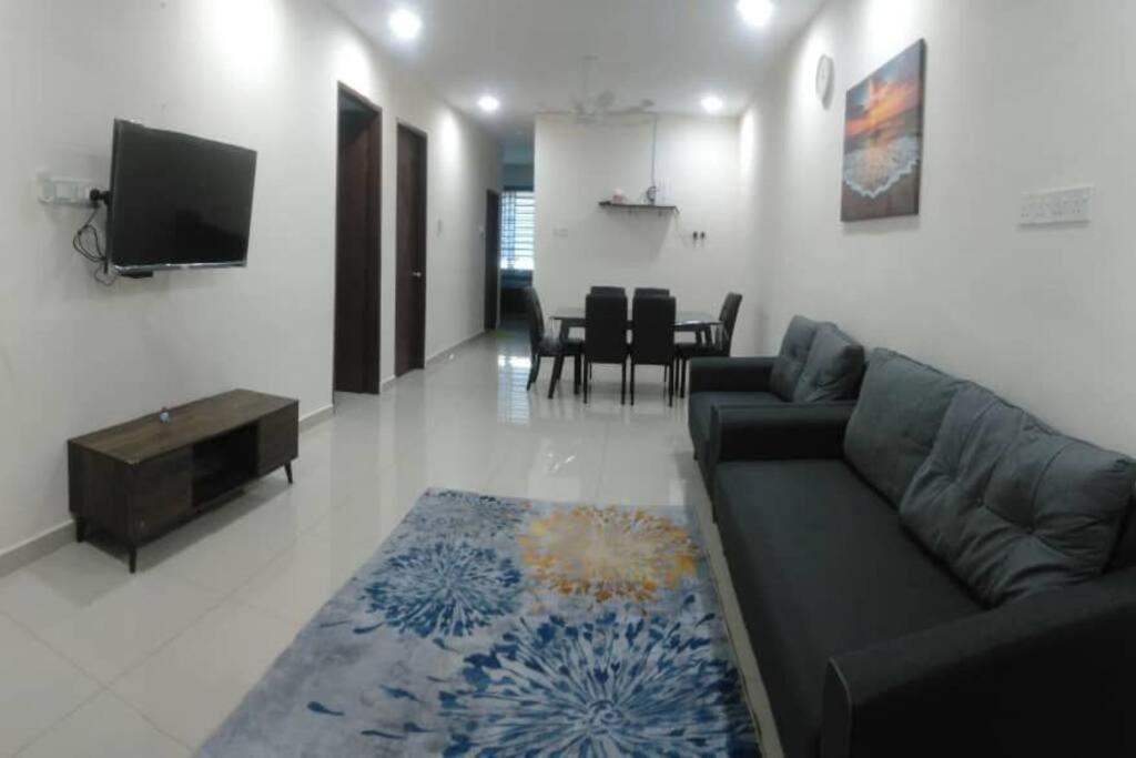 sala de estar con sofá y TV en KITAKAYA Homestay Kota Bharu - 8 Pax, en Kota Bharu