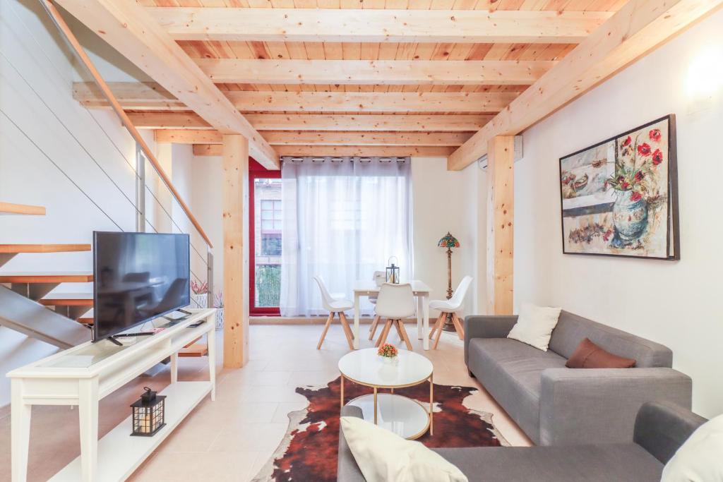 a living room with a couch and a tv at Bright duplex apartment for families-VICALV in Madrid