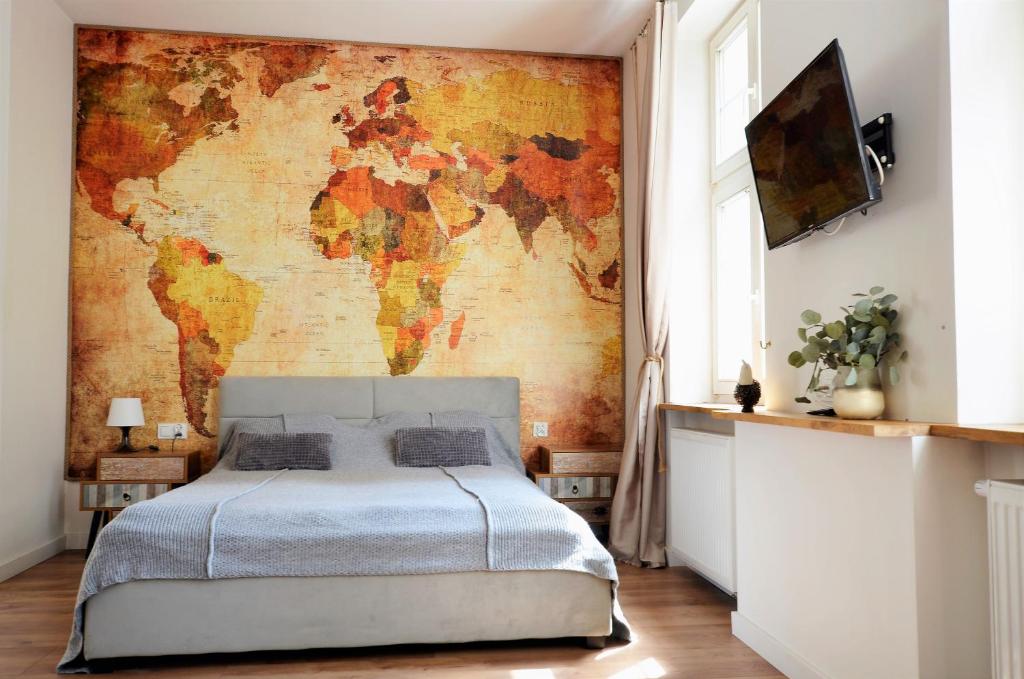 a bedroom with a map of the world on the wall at Apartament Szeroka Old Town in Gdańsk