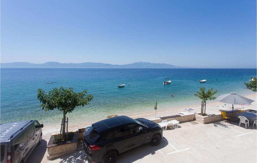 a car parked next to a beach with boats in the water at Gorgeous Home In Brist With House Sea View in Brist