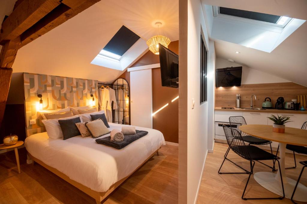 een slaapkamer met een bed en een tafel en een keuken bij Appart-hôtel de standing avec jacuzzi privatisable en option in Périgueux