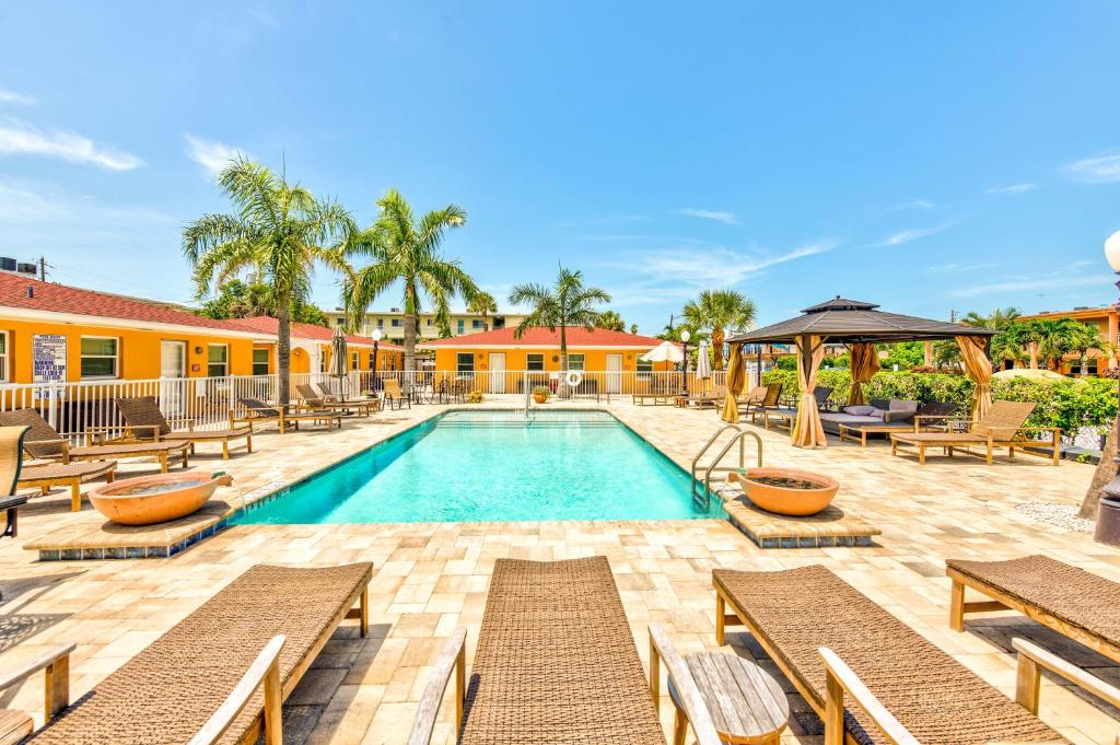 a swimming pool with chaise lounges and benches at Upham Beach Inn - #8 1BR Suite in St. Pete Beach