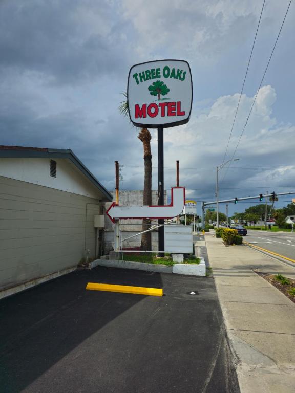 ein Drei-Ovations-Motel-Schild an der Seite einer Straße in der Unterkunft Three Oaks Motel - Titusville in Titusville