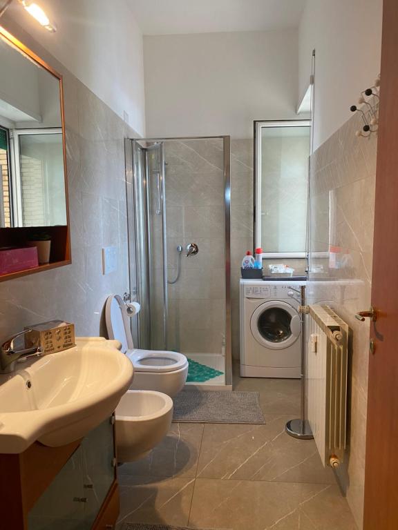 a bathroom with a toilet and a sink and a washing machine at Pisana 247 St Peter in Rome
