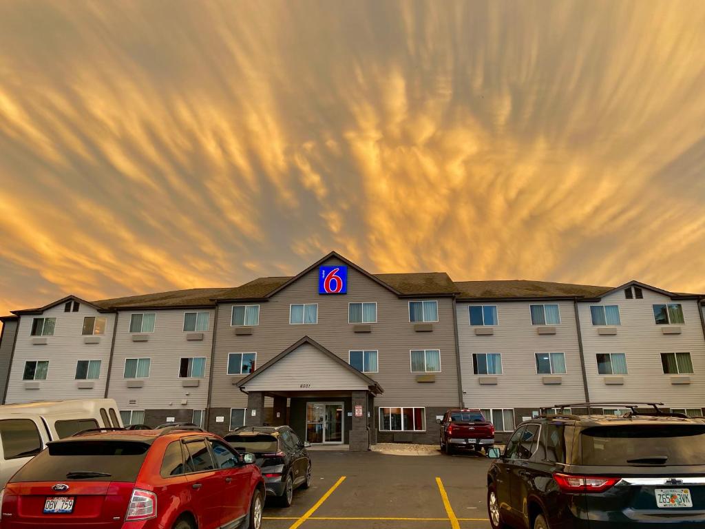 een groot gebouw met auto's geparkeerd op een parkeerplaats bij Motel 6-Lincoln, NE in Lincoln