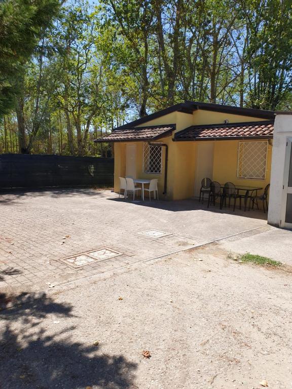 a building with a table and chairs in a driveway at Residence natura beach in Lido di Volano