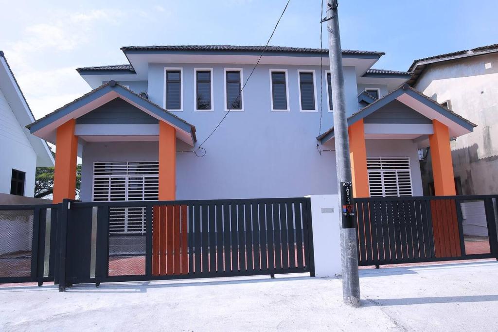 ein Haus mit einem schwarzen Tor davor in der Unterkunft Green Dream Homestay 2 Kota Bharu Town 3 Aircond Room With Wifi & Netflix in Kota Bharu