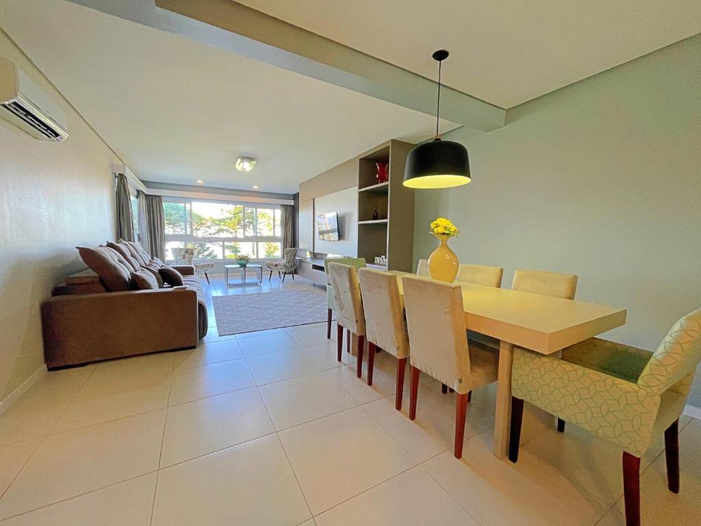 ein Esszimmer und ein Wohnzimmer mit Tisch und Stühlen in der Unterkunft Espaçoso apto no Centro de Gramado in Gramado