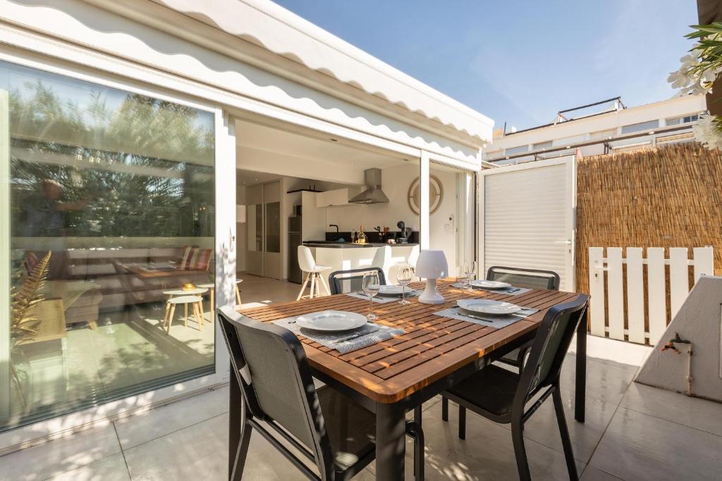 une table et des chaises en bois sur une terrasse dans l'établissement Village Naturiste R4N - La Villa Gypsea Luxe, au Cap d'Agde