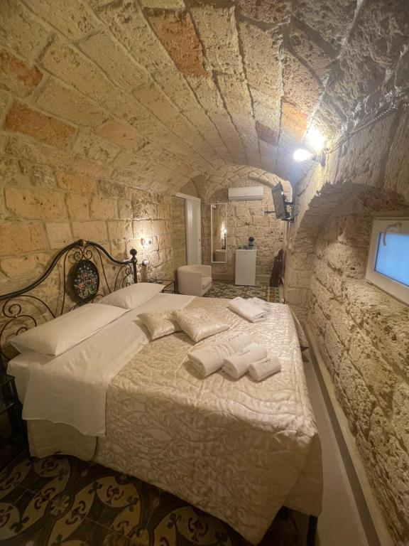 een slaapkamer met een bed in een stenen muur bij B&B DAMAPAGA Palazzo GRAPPA in Galatina