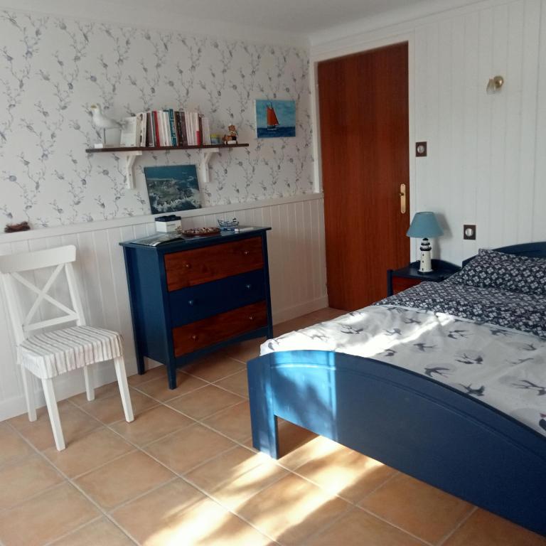 - une chambre avec un lit, une chaise et une commode dans l'établissement Maison La Belvérine, à Beauvoir-sur-Mer