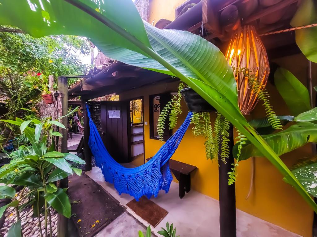 una hamaca en el patio de una casa con plantas en Pousada Raiz Forte, en Caraíva