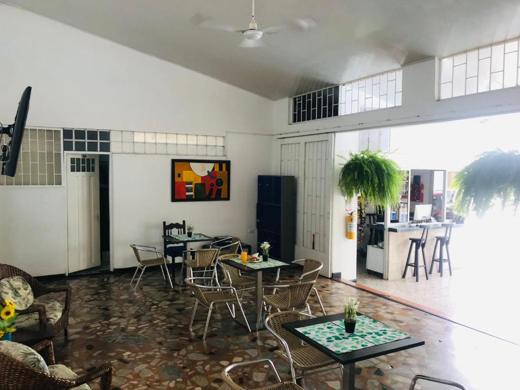 a room with tables and chairs and a kitchen at HOTEL MACEO MELGAR in Melgar