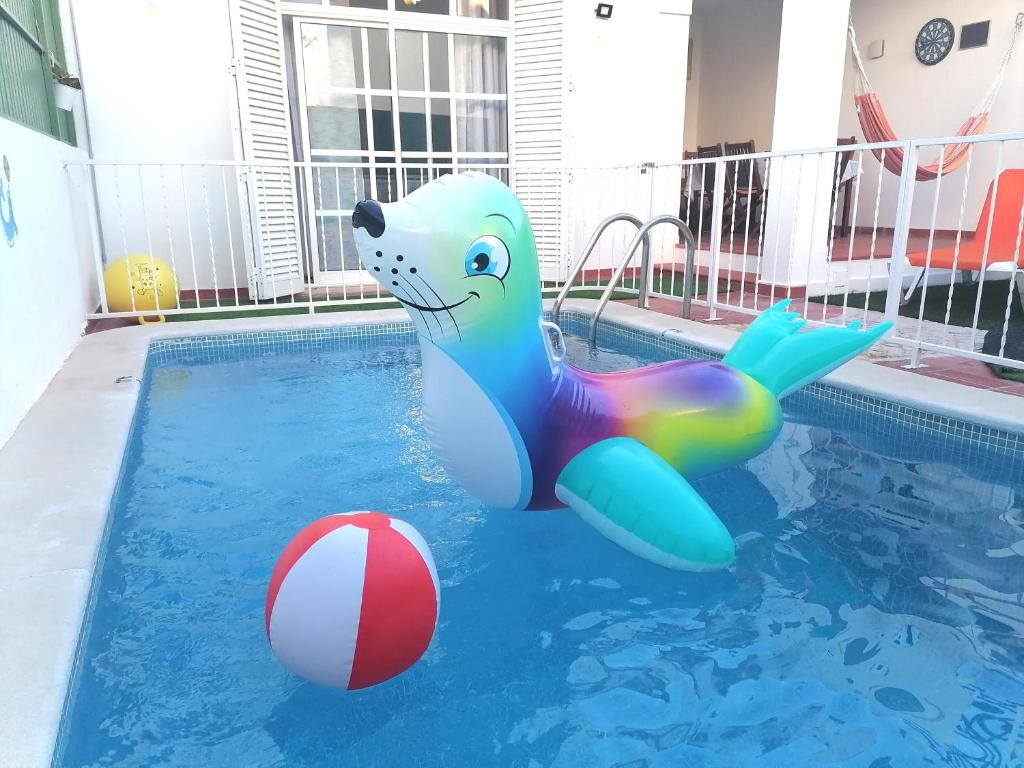 a dolphin inflatable in a pool with a ball at Marreiro's house Algarve - Child friendy - Private Pool in Lagos