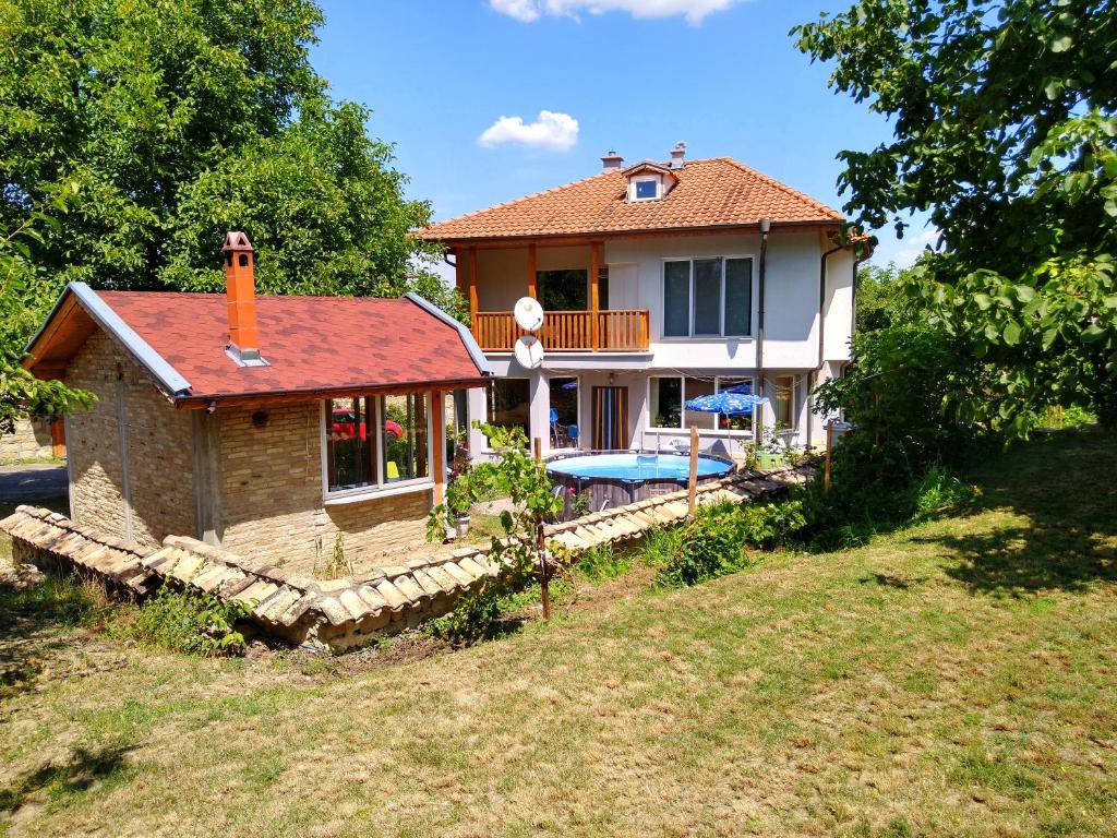 una piccola casa con tetto rosso e cortile di Бялата къща Калугерица a Kaspichan