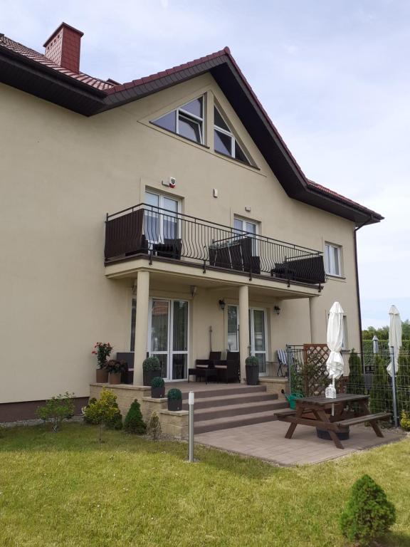 a house with a balcony and a bench at Villa Spokojna 26 in Mielno
