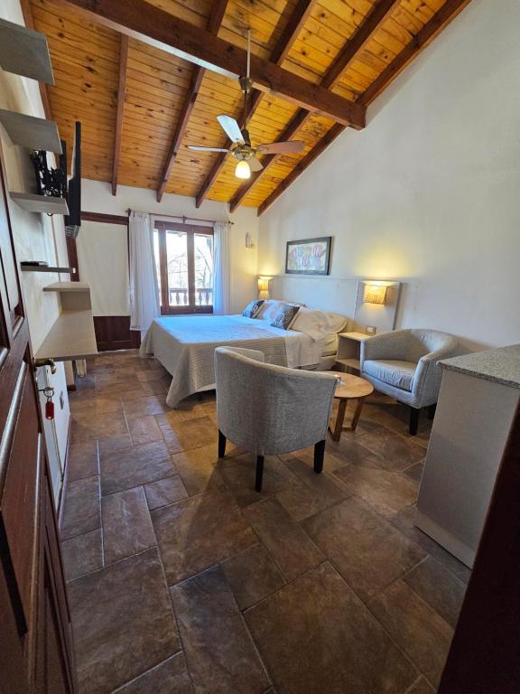 a large living room with a bed and a couch at Posada Aitue in Villa General Belgrano