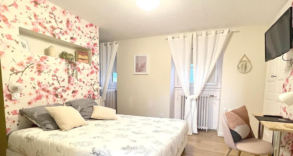 a bedroom with a bed with flowers on the wall at Chambre Crémant - Maison Bossoreil in Angers