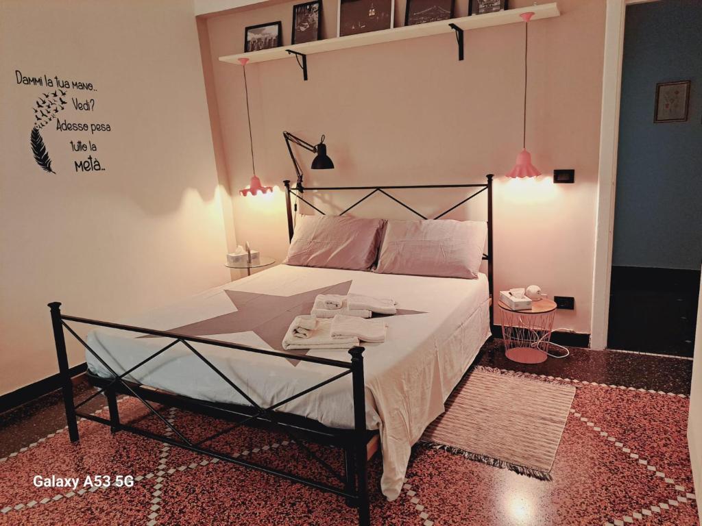 Un dormitorio con una cama con sábanas blancas y almohadas rosas. en La Chiabretta, en Génova