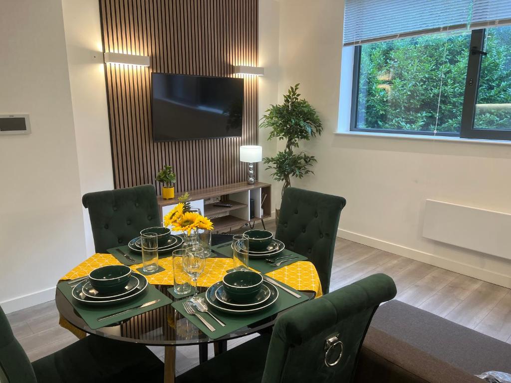 a dining room with a table and chairs and a television at Esmae Homes in Milton Keynes