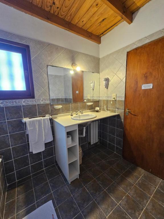 un bagno con lavandino e specchio di Posada Aitue a Villa General Belgrano