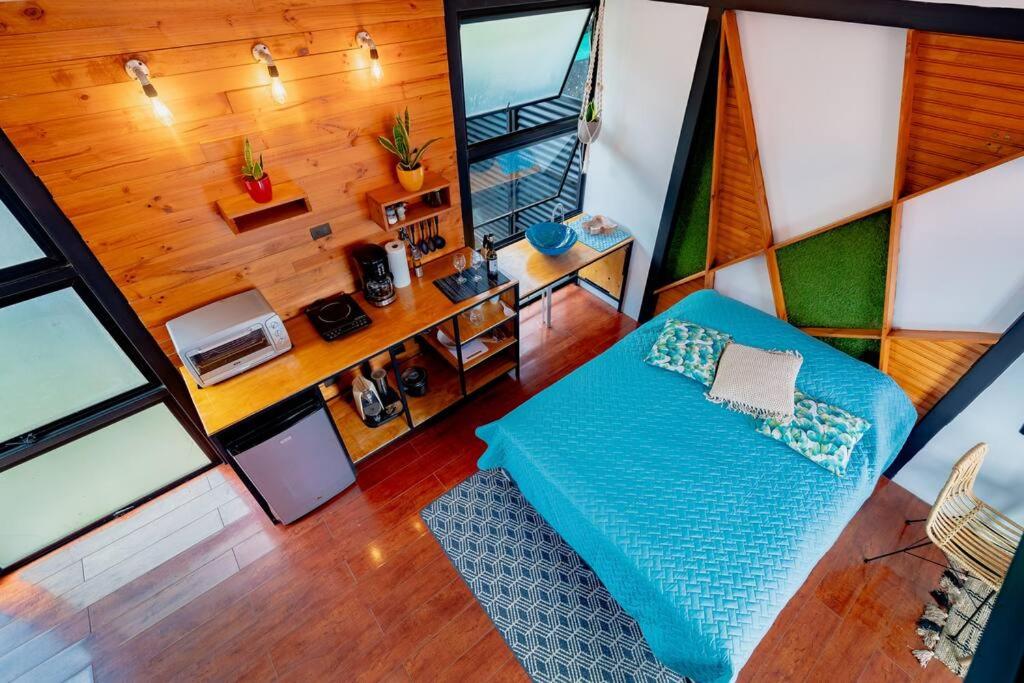 einen Blick über ein Wohnzimmer mit einem blauen Sofa in der Unterkunft Olly´s House in Turrialba