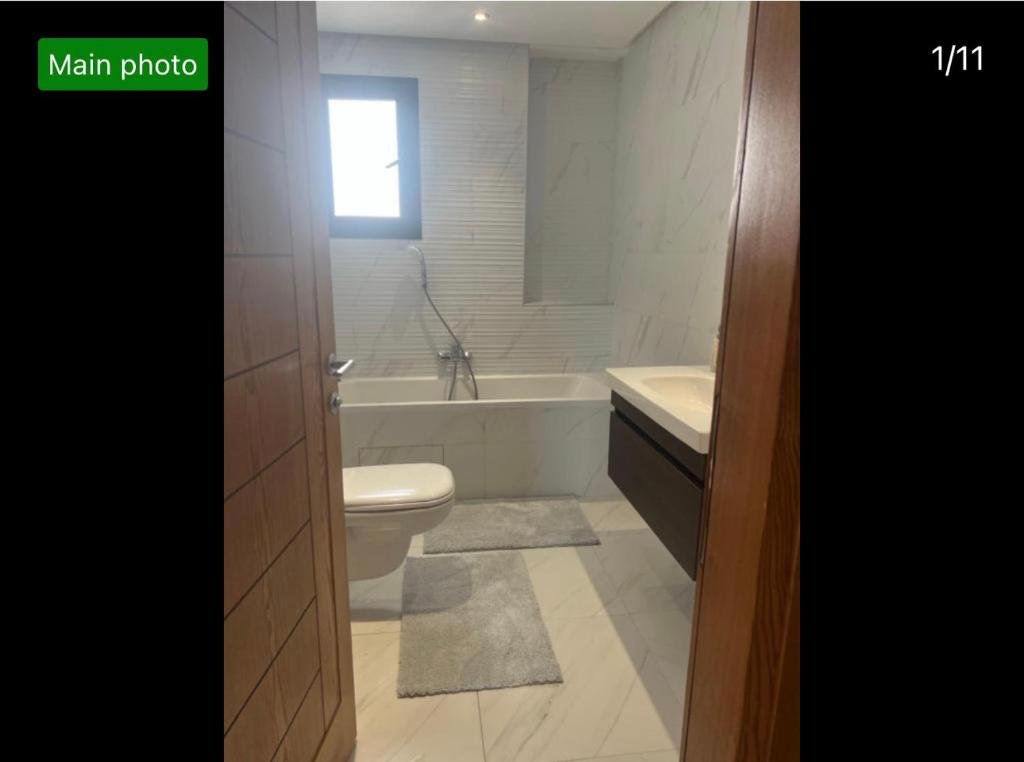a bathroom with a toilet and a tub and a sink at Residence prestige in Nabeul