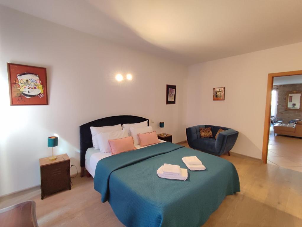 - une chambre avec un lit doté d'une couverture bleue et d'une chaise dans l'établissement CASA DI ARTISTI AJACCIO - Holiday Homes - Classé 5 étoiles - EXCEPTIONNEL, à Ajaccio