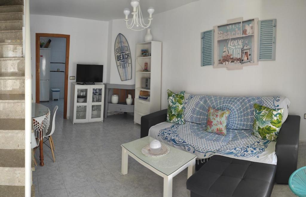 ein Wohnzimmer mit einem Sofa und einem Tisch in der Unterkunft islantilla adosado piscina parking 1 minuto al mar in Islantilla