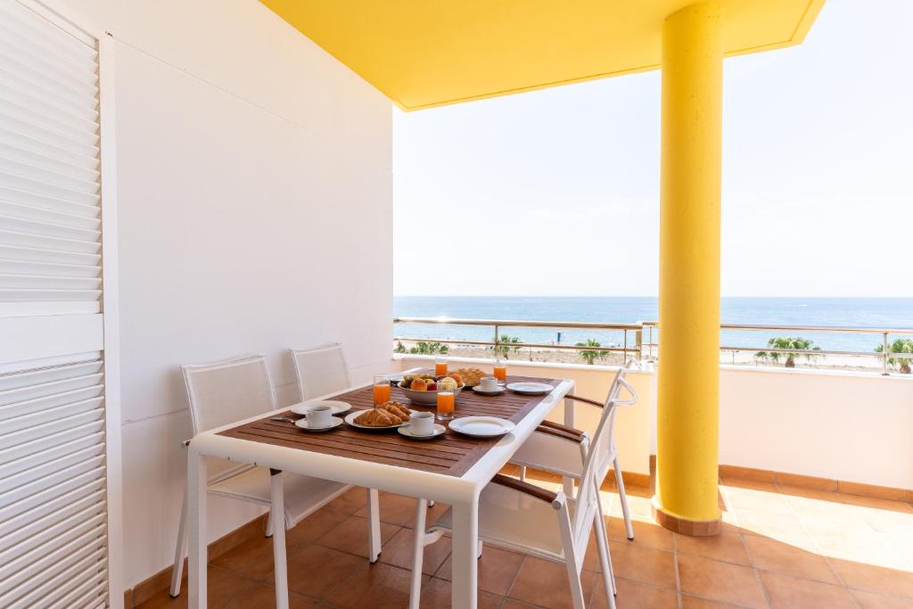 a dining room with a table and chairs and the ocean at Trendy Homes Almerimar Seaview Penthouse in Almerimar