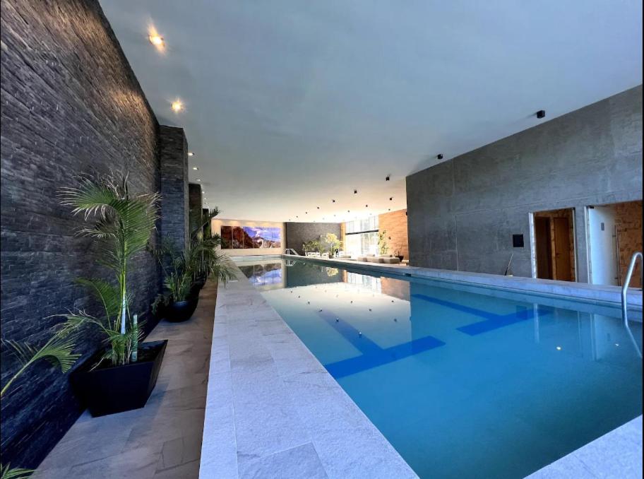 a swimming pool with blue water in a building at Luxury 4BR Apartment w Pool, Spa & Stunning Views in Puebla