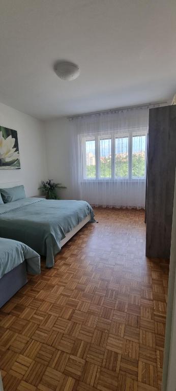 1 dormitorio con 2 camas y suelo de madera en B&B al quadrifoglio posto auto, en Trieste