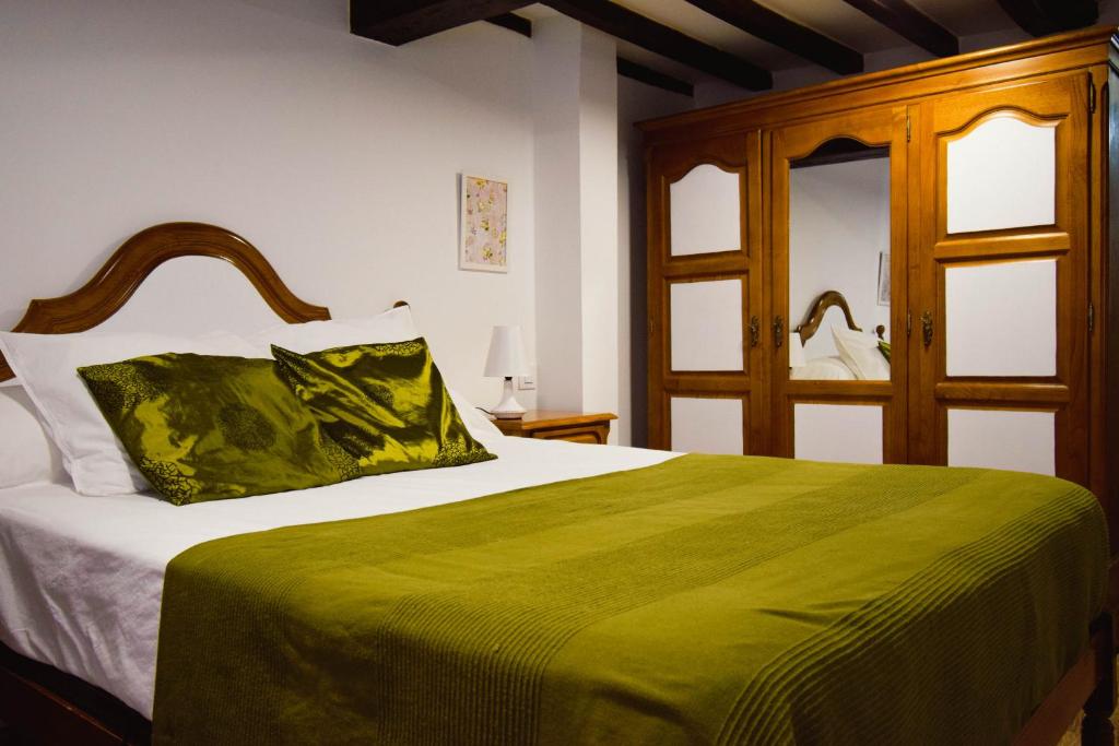1 dormitorio con 1 cama grande con manta verde en Casa Rural El Sobraillo, en Villanueva de la Vera