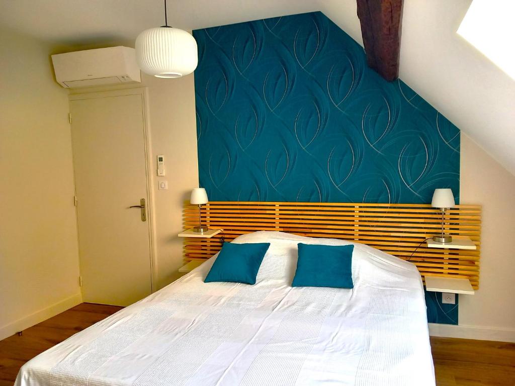 - une chambre dotée d'un lit avec un mur bleu dans l'établissement CHAMBRE D HOTES AU COEUR DE MEURSAULT, à Meursault