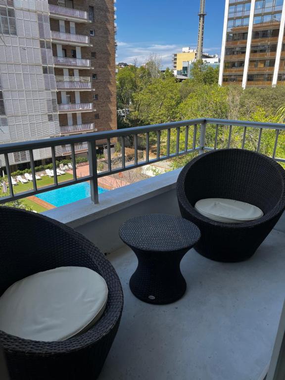 d'un balcon avec deux chaises, une baignoire et une table. dans l'établissement Precioso y tranquilo apartamento zona alta Diagonal Barcelona, à Barcelone