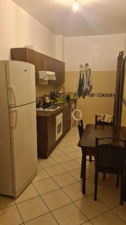 uma cozinha com um frigorífico branco e uma mesa em Aziz agadir em Agadir
