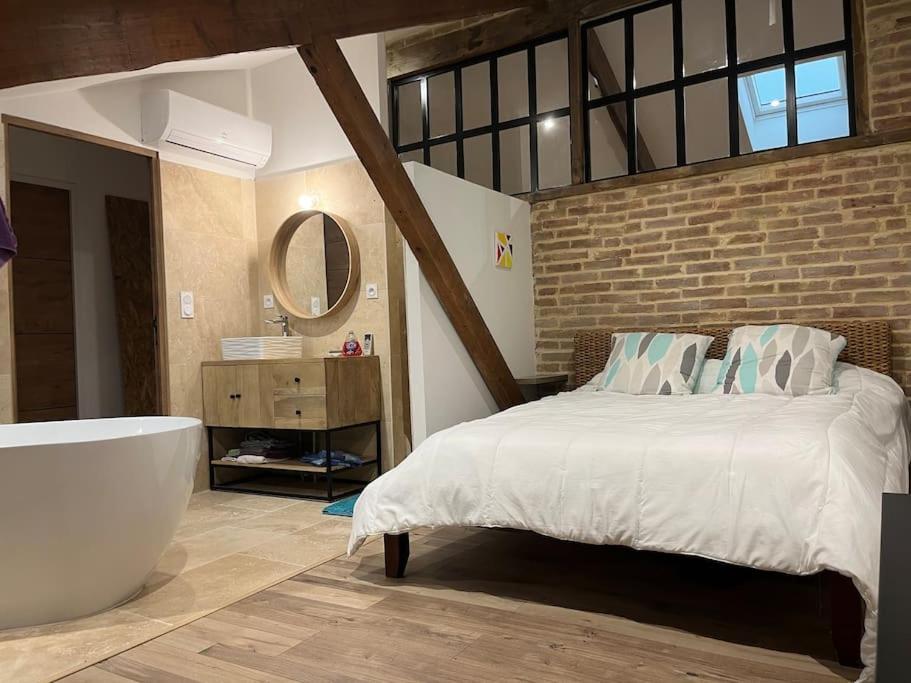 1 dormitorio con 1 cama grande y bañera en Loft style industriel, en Bagnols-sur-Cèze